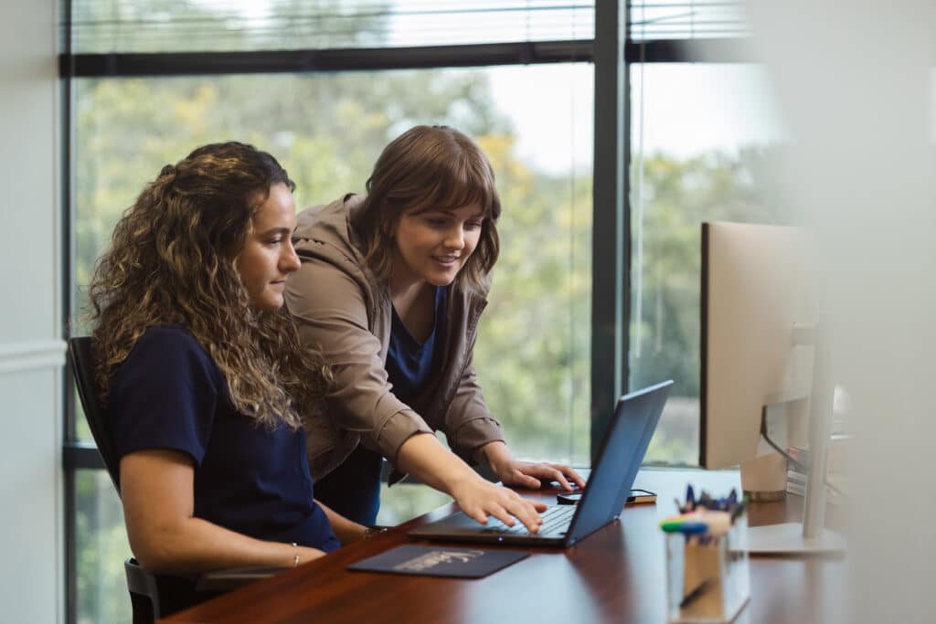 Practice staff reviewing software together at a workstation