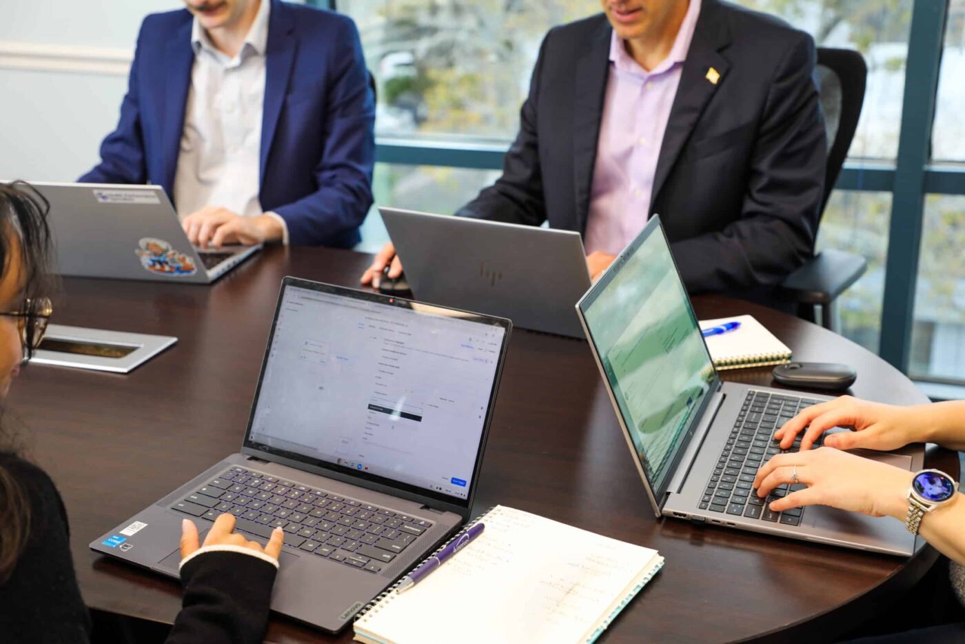 HPS team collaborating around laptops during a meeting